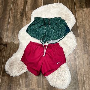 2 Nike drawstring running shorts with zipper pocket.